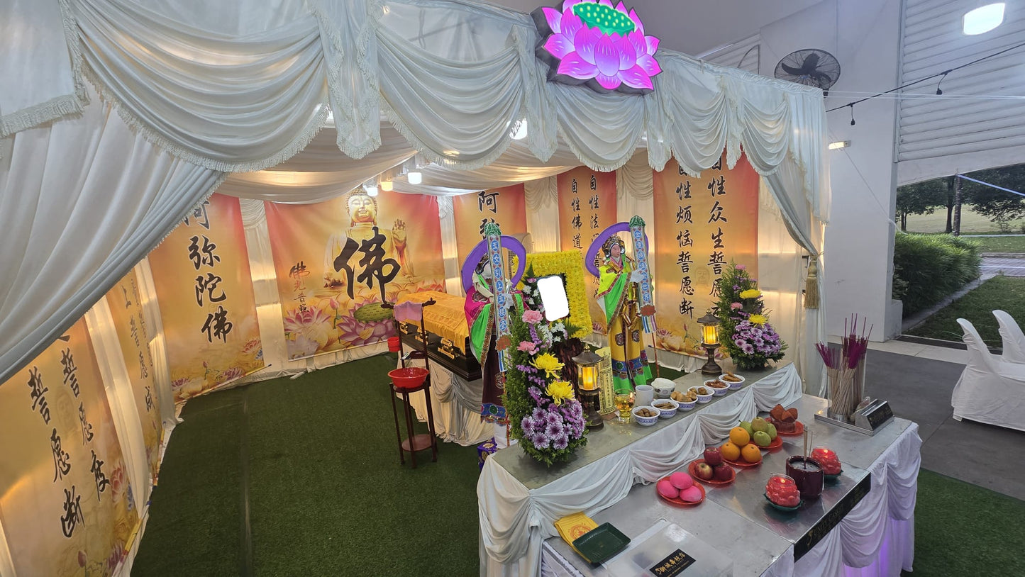 Decorative setup with floral arrangements, fruits, and religious symbols inside a tent.
